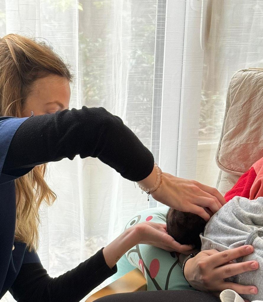 Les mains de Laura Rivallan posées sur la tête d'un nourrisson
